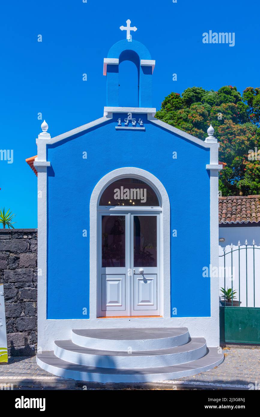 Cappella blu di fronte al mulino a vento Pico Vermelho sull'isola di Sao Miguel, Portogallo. Foto Stock