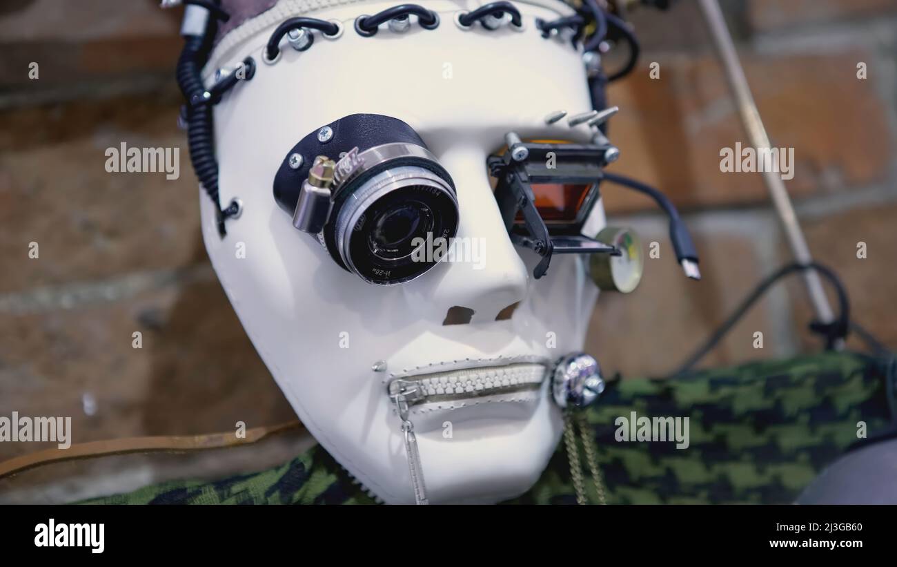 Maschera robot in stile cyberpunk. ARTE. Maschera di plastica bianca con  telecamere negli occhi. La faccia del robot in fili neri è inchiodata ad  una parete di mattone Foto stock - Alamy