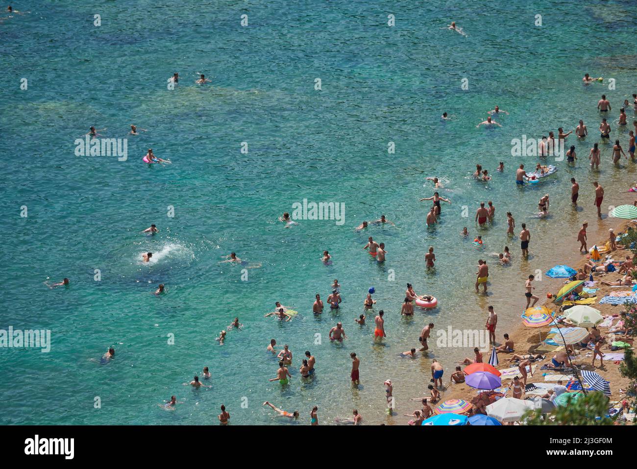 BUDVA, MONTENEGRO - 25 LUGLIO 2021: Molte persone nuotano in mare sulla spiaggia Foto Stock