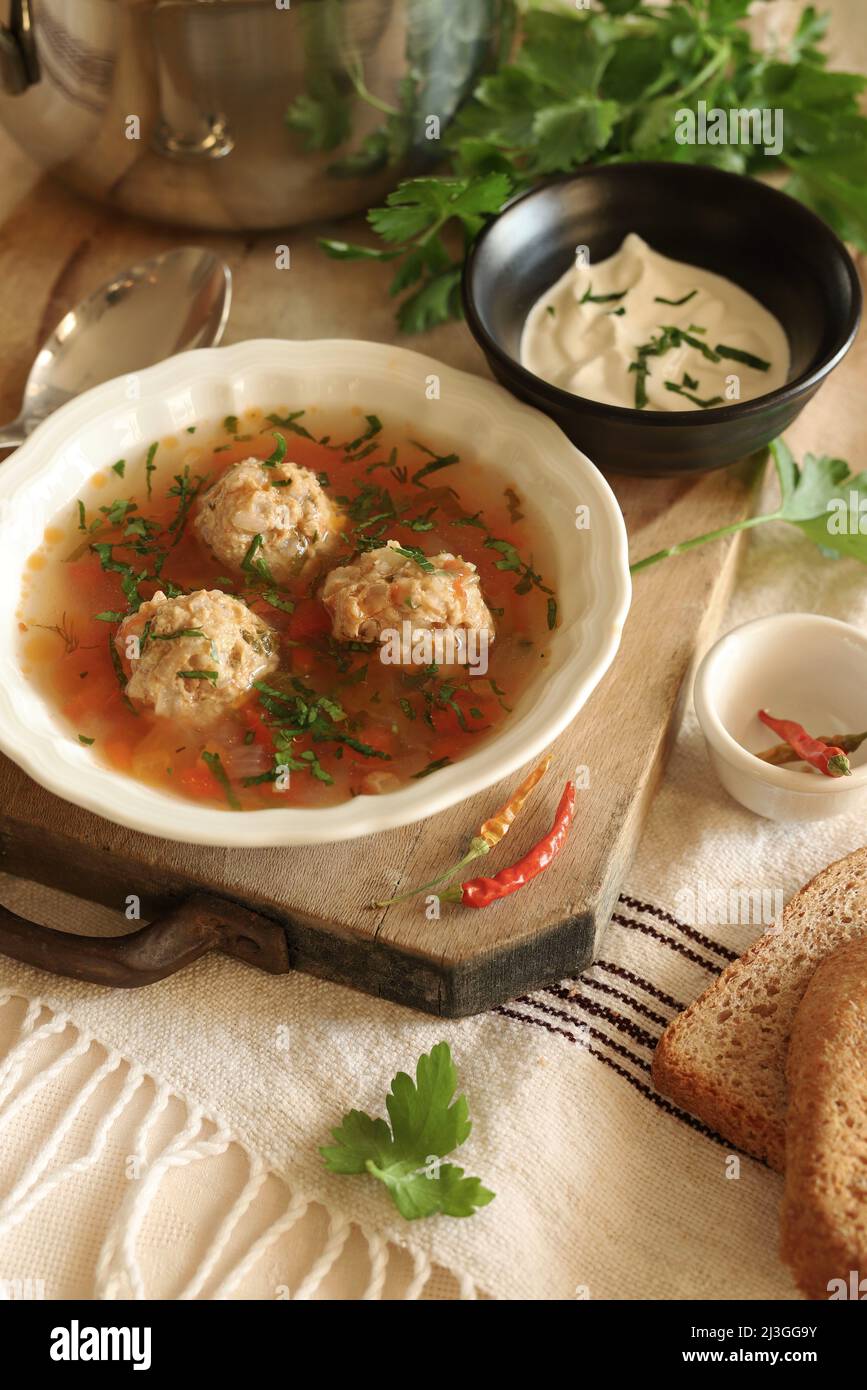 Zuppa con polpette e verdure isolate sul tavolo. Cucina rumena. Spazio di copia. Direttamente sopra. Foto Stock