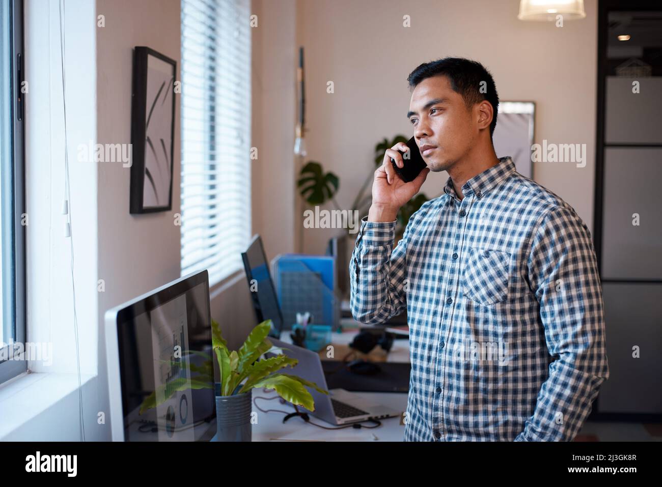 Un uomo d'affari serio in una telefonata che guarda grafici e dati Foto Stock