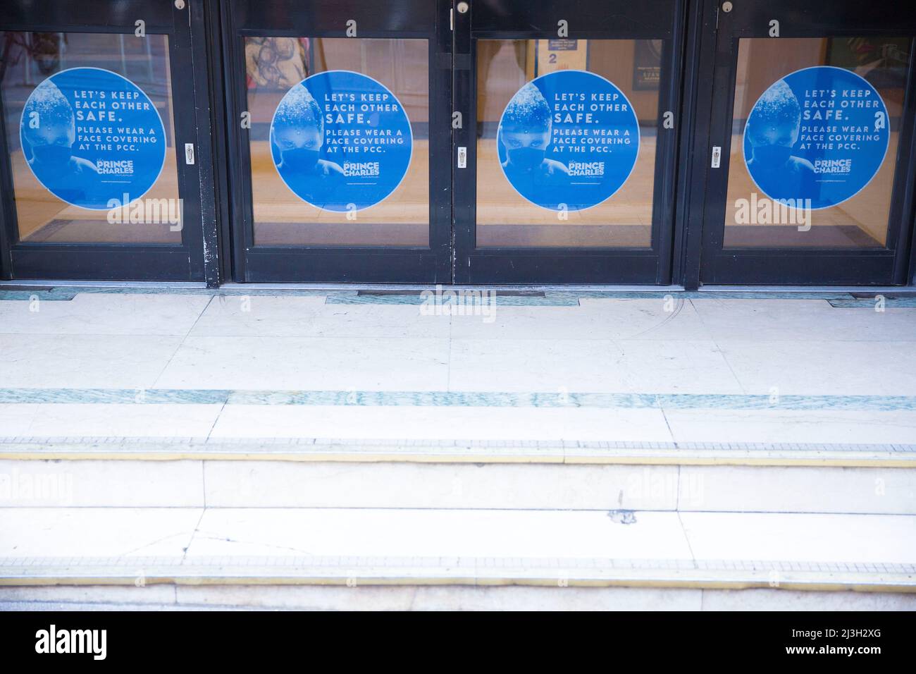 Le istruzioni per la copertura del volto sono visualizzate al Prince Charles Cinema nel centro di Londra. Foto Stock