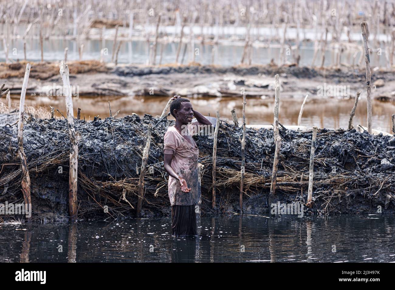 Uganda, distretto Kasese, Katwe, lago del cratere Katwe, donna che rimuove il fango dal suo appezzamento di sale Foto Stock