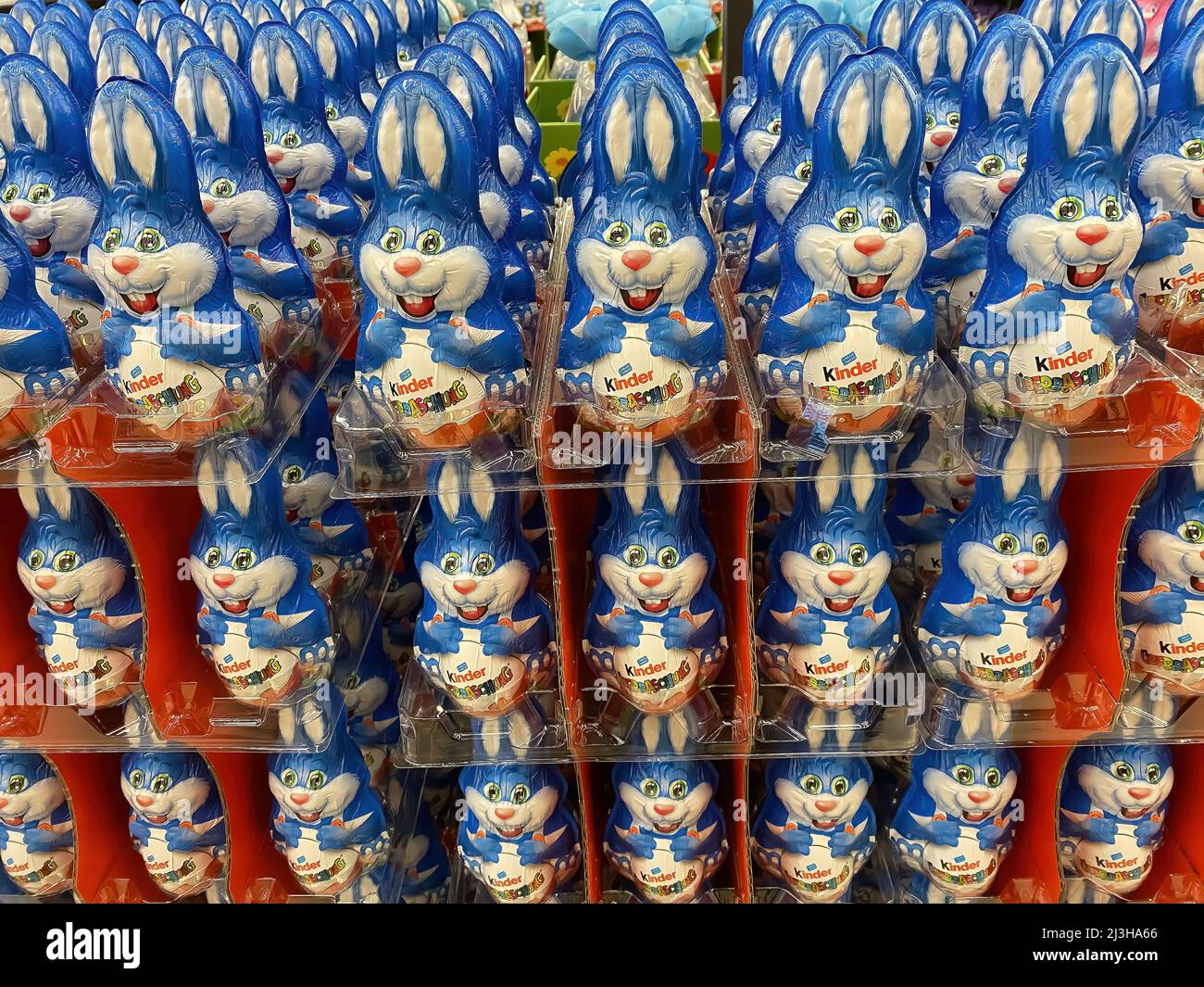 Viersen, Germania - Aprile 5. 2022: Primo piano di innumerevoli coniglietti di pasqua di cioccolato kinder blu accatastati in file nel supermercato tedesco Foto Stock