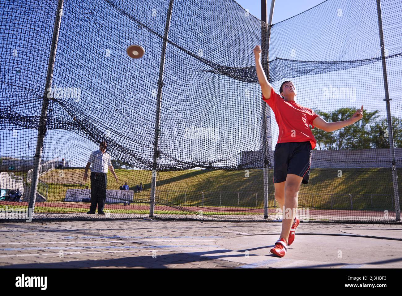 Questo un record breaker. Scatto di un giovane sportivo che lancia un disco. Foto Stock