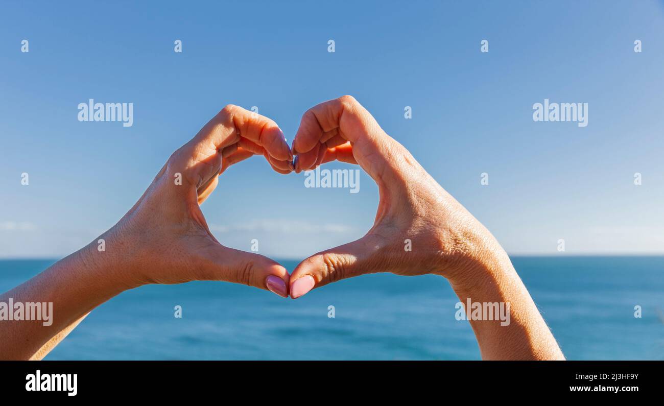 Le mani formano un cuore nella baia di Bolata sul Mar Nero in Bulgaria Foto Stock