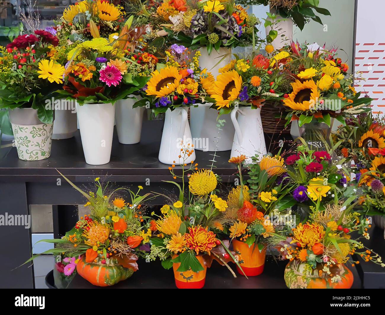 Bouquet colorati con molti girasoli gialli in negozio di fiori Foto Stock