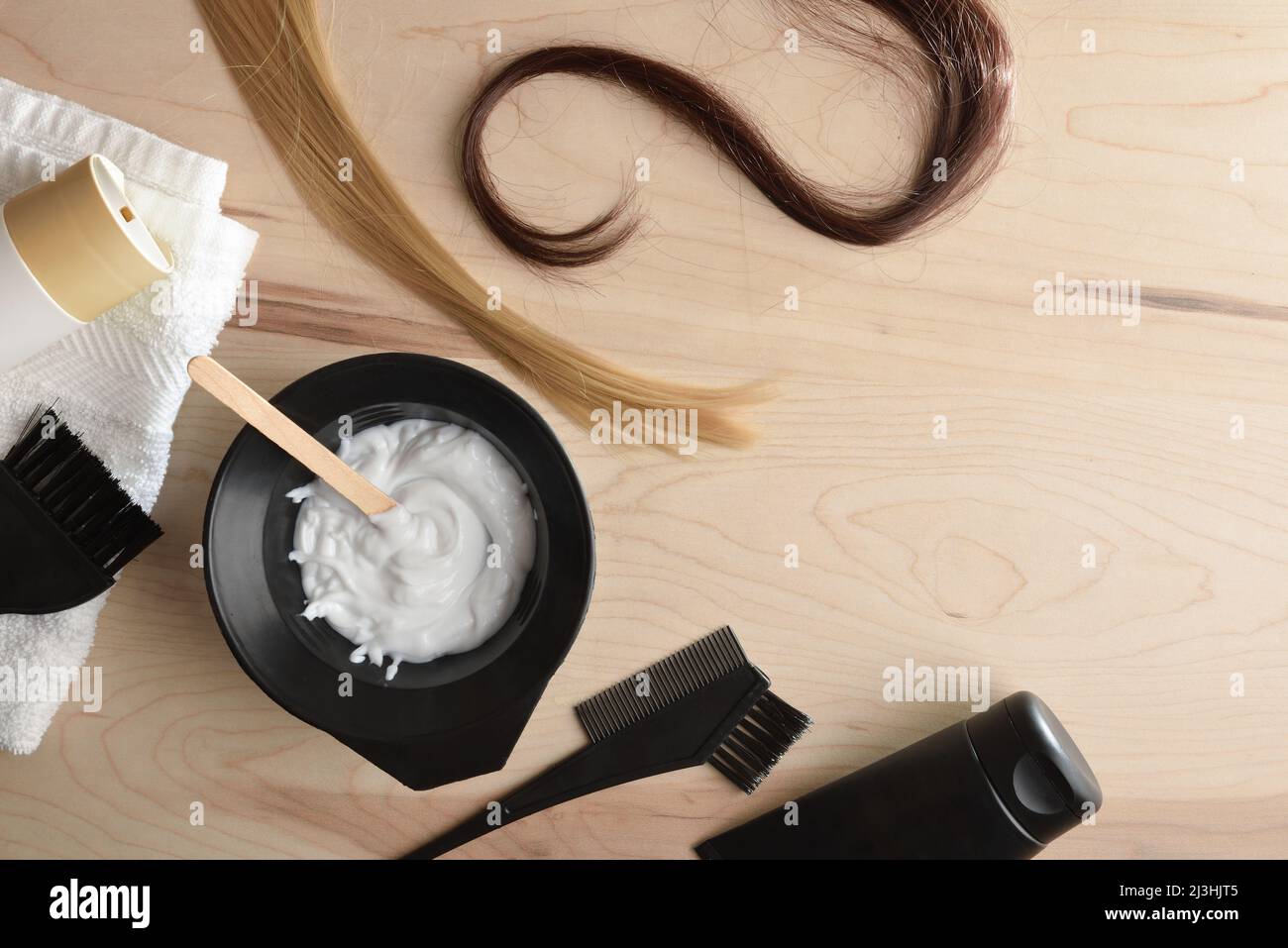 Trattamento di prodotti per la cura dei capelli e la colorazione da un salone stilista su tavola di legno. Vista dall'alto. Composizione orizzontale. Foto Stock