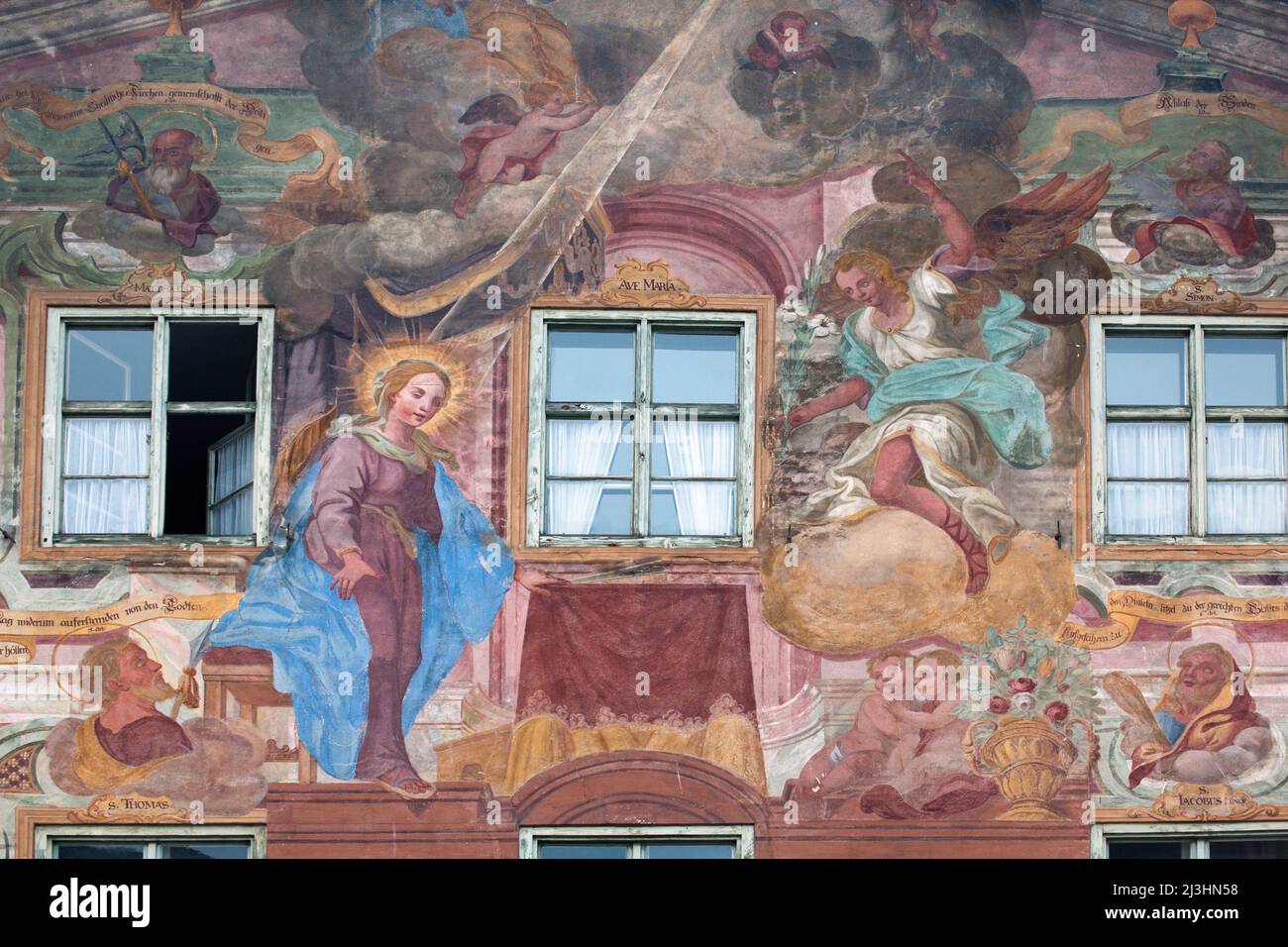 In una scena dell'Annunciazione a Maria, l'angelo porta a Maria un giglio bianco, scena biblica, Lüftlmalerei (pittura tradizionale) sulla facciata della casa a Mittenwald, in alta Baviera Foto Stock