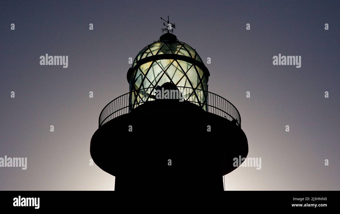 Spagna, Isole Canarie, Fuerteventura, punta sud-occidentale, paesaggio arido, Punta de Jandia, faro, parte superiore del faro in controluce Foto Stock