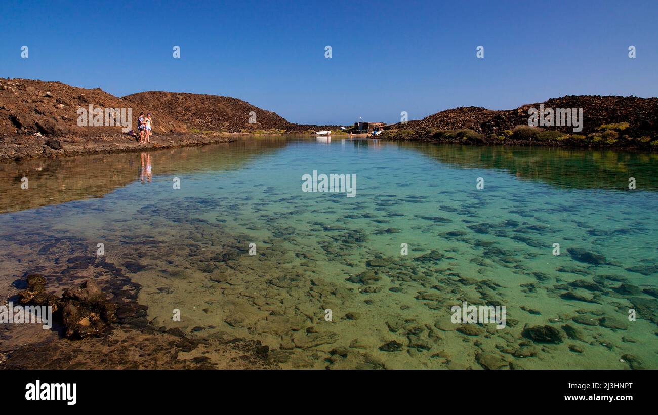 Spagna, Isole Canarie, Fuerteventura, gita in barca a vela, Isola di Los Lobos, riserva naturale, bassa, laguna verde, acque cristalline, turisti di sinistra piccola in foto, cielo blu e nuvoloso Foto Stock