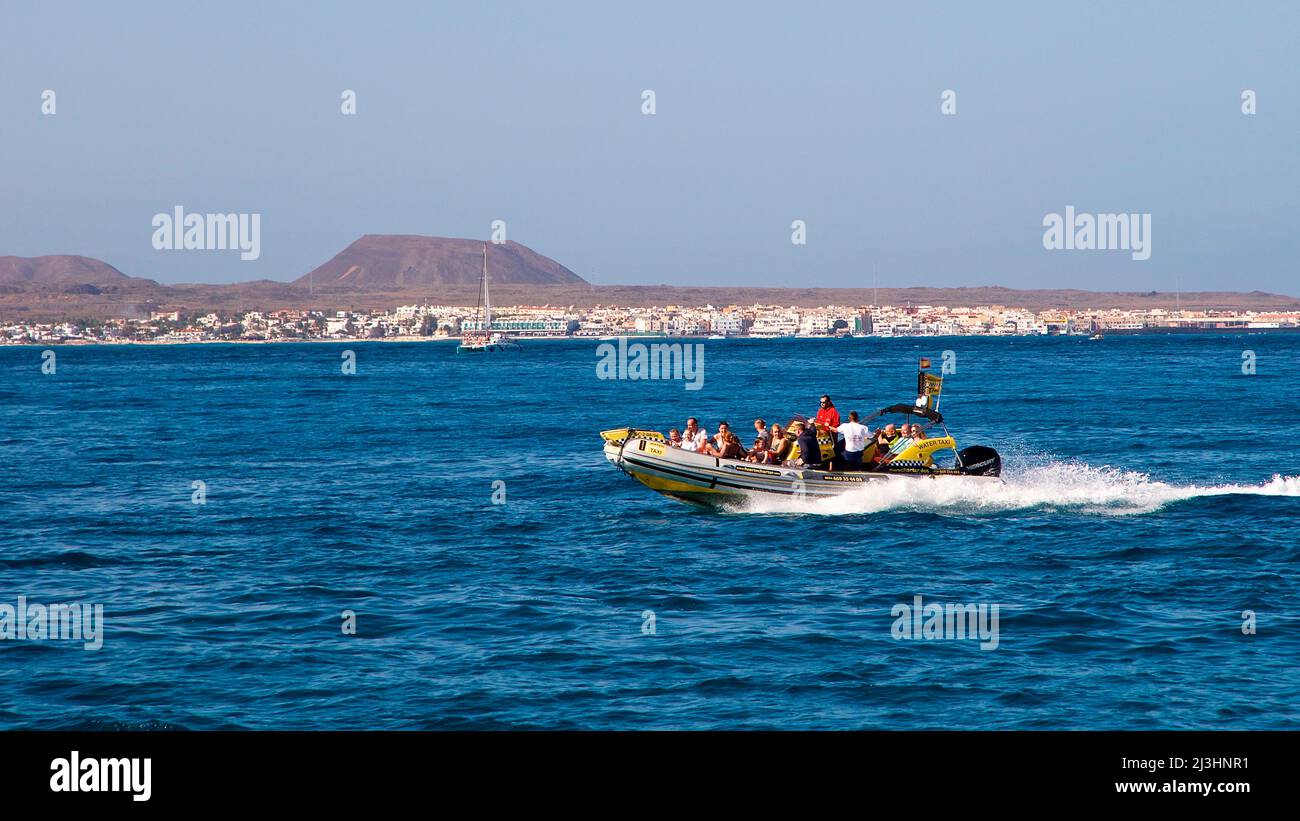 Spagna, Isole Canarie, Fuerteventura, gita in barca a vela, Isola di Los Lobos, Riserva naturale, veloce dinghy va verso Corralejo, mare blu, cielo azzurro e nuvoloso Foto Stock
