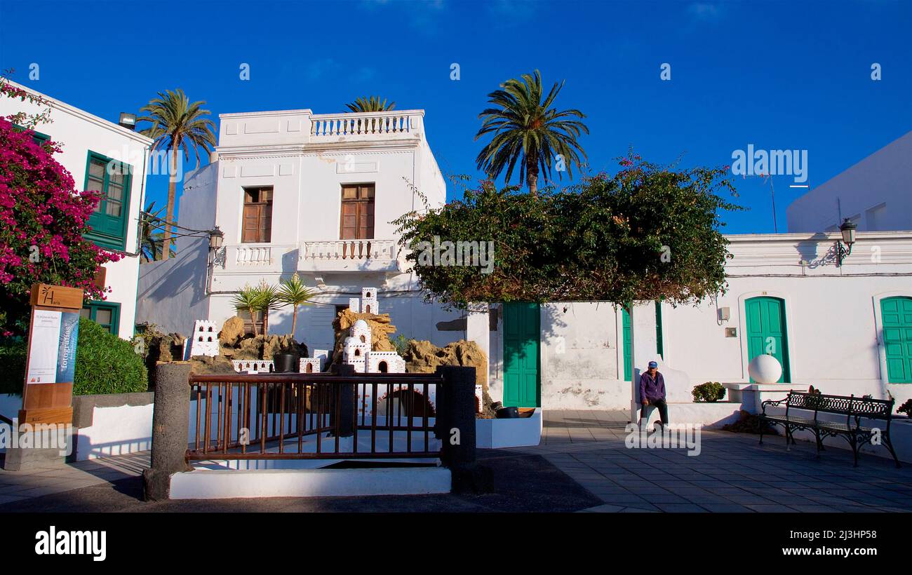 Isole Canarie, Lanzarote, isola vulcanica, a nord dell'isola, città oasi, Haria, piazza del villaggio, complesso con case in miniatura e fontana, palme, case bianche, azzurro cielo Foto Stock
