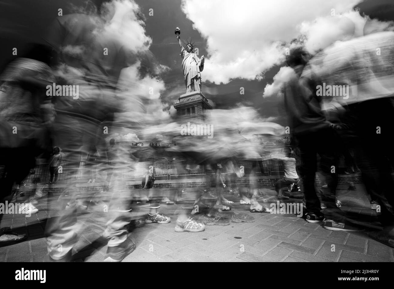 Liberty Island, New York City, NY, USA, lunga esposizione della Statua della libertà e turisti che sono sfocati e in movimento Foto Stock