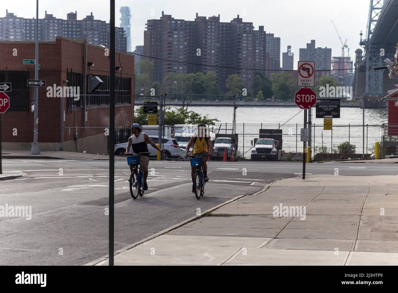 KENT Av/S 6 Street, New York City, NY, USA, due ciclisti di fronte al fiume est Foto Stock