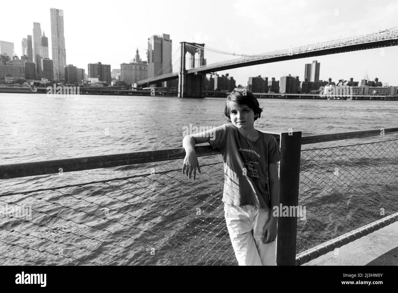 Dumbo/FULTON FERRY, New York City, NY, USA, adolescente caucasico di 12 anni - con capelli marroni e in estate vestito di fronte al Ponte di Brooklyn sopra East River Foto Stock