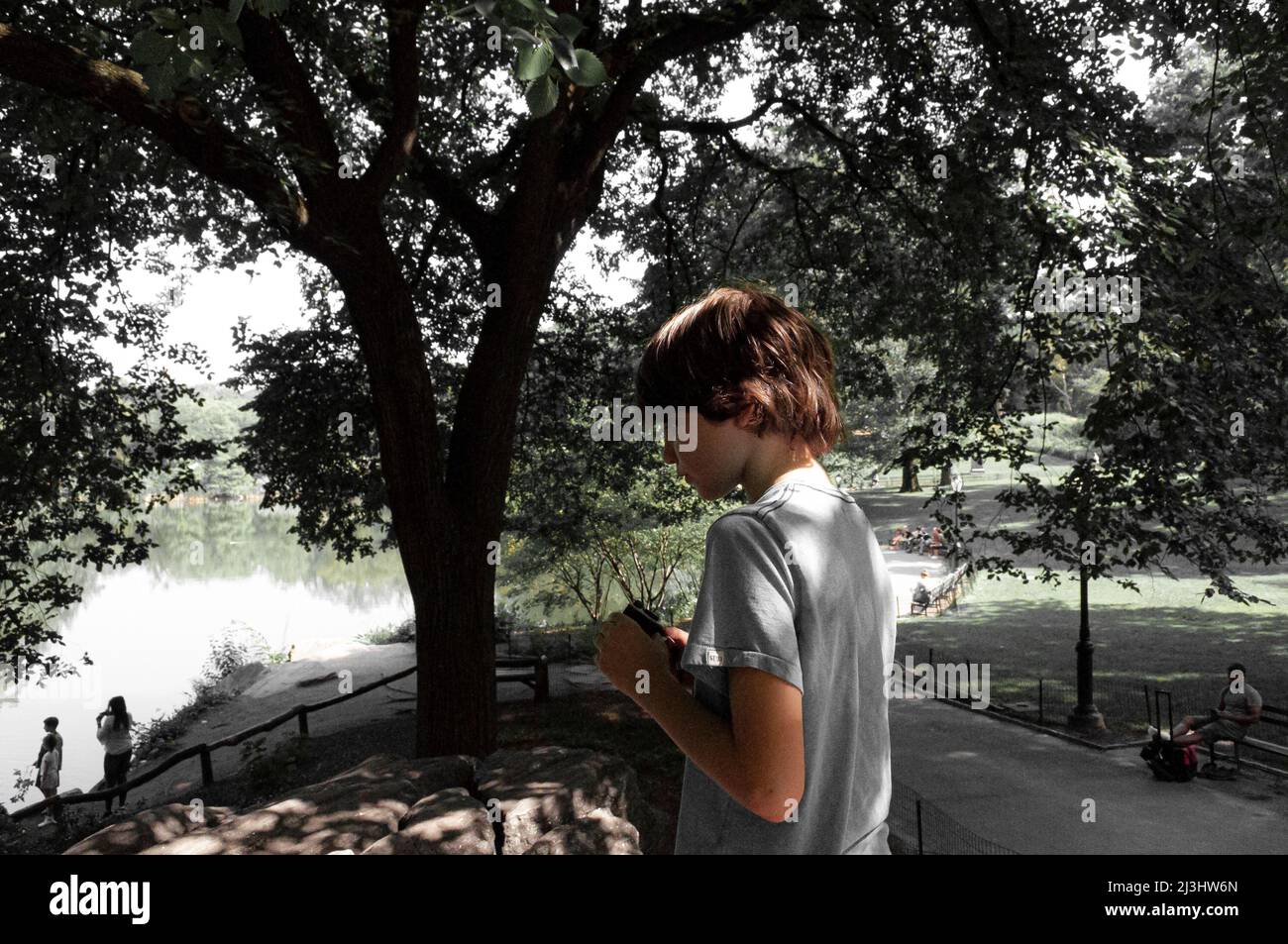 5 Av/59 Street, New York City, NY, USA, giovane ragazzo al Central Park 12 anni ragazzo caucasico - con capelli marroni e in estate vestito al Central Park Foto Stock