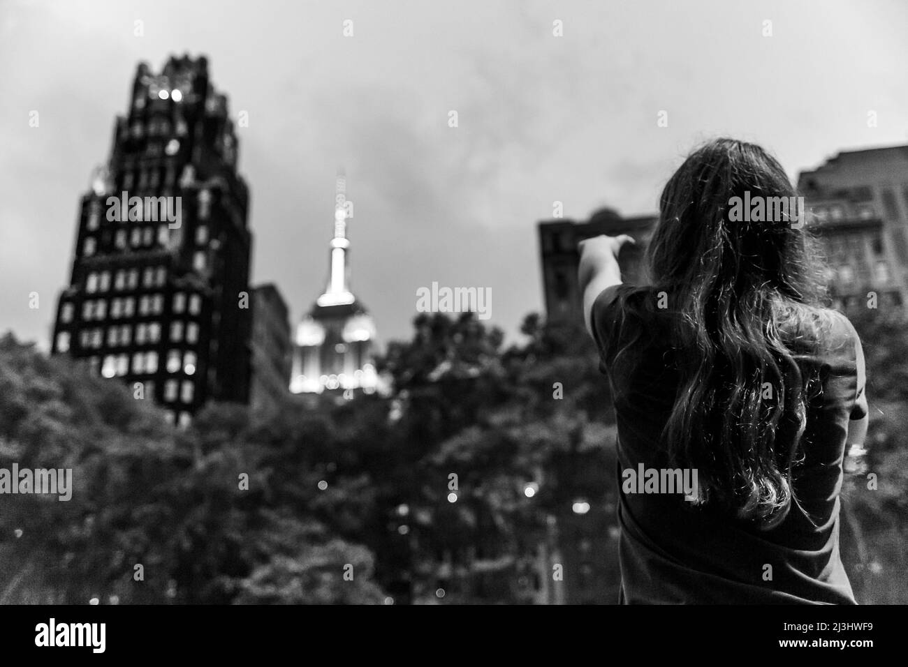 Midtown SOUTH, New York City, NY, USA, Young Girl che punta all'Empire state Building da Bryant Park Foto Stock