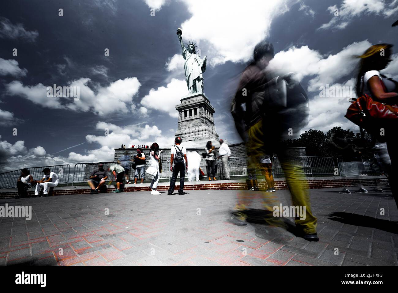LIBERTY ISLAND, New York City, NY, USA, lunga esposizione della Statua della libertà e turisti che sono sfocati e in movimento Foto Stock