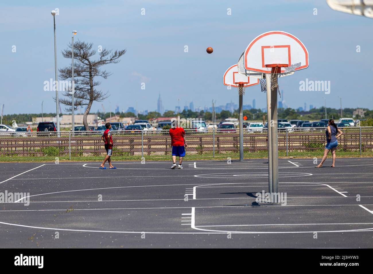 JACOB RIIS PARK ROAD/BATH HOUSE, New York City, NY, USA, campo da pallacanestro con skyline di nyc sullo sfondo Foto Stock