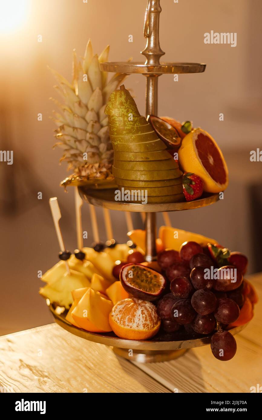 Materie frutti bacche platter, mango, arance e kiwi fragole, mirtilli pompelmo uva, banane mele sulla piastra bianca, sul bianco tabl Foto Stock