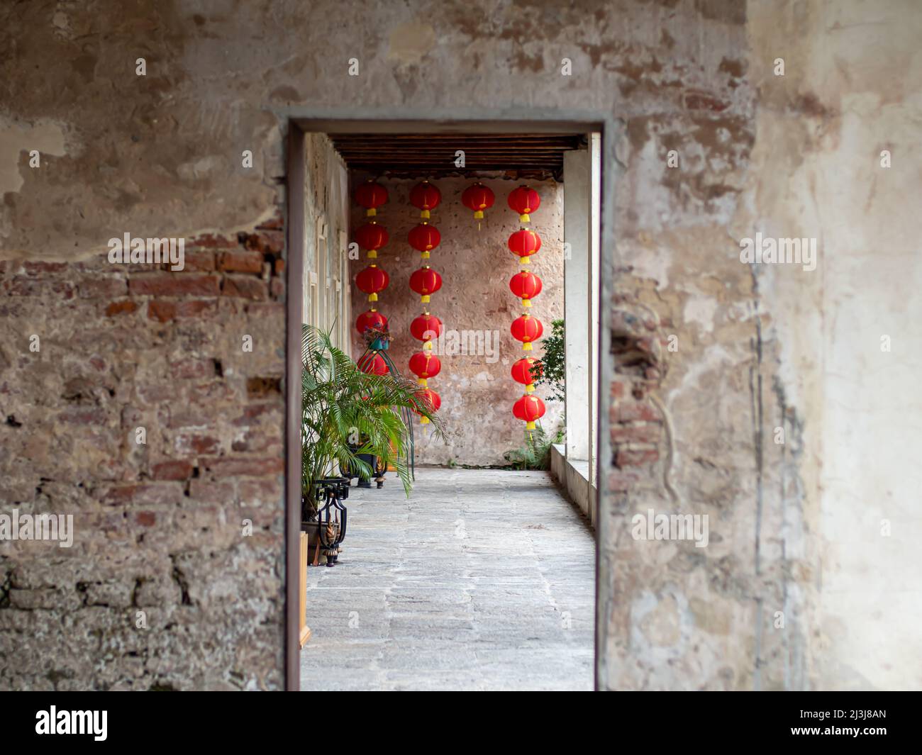 L'entrata in cemento sfocato come scontata, lanterna cinese appesa al muro. Foto Stock