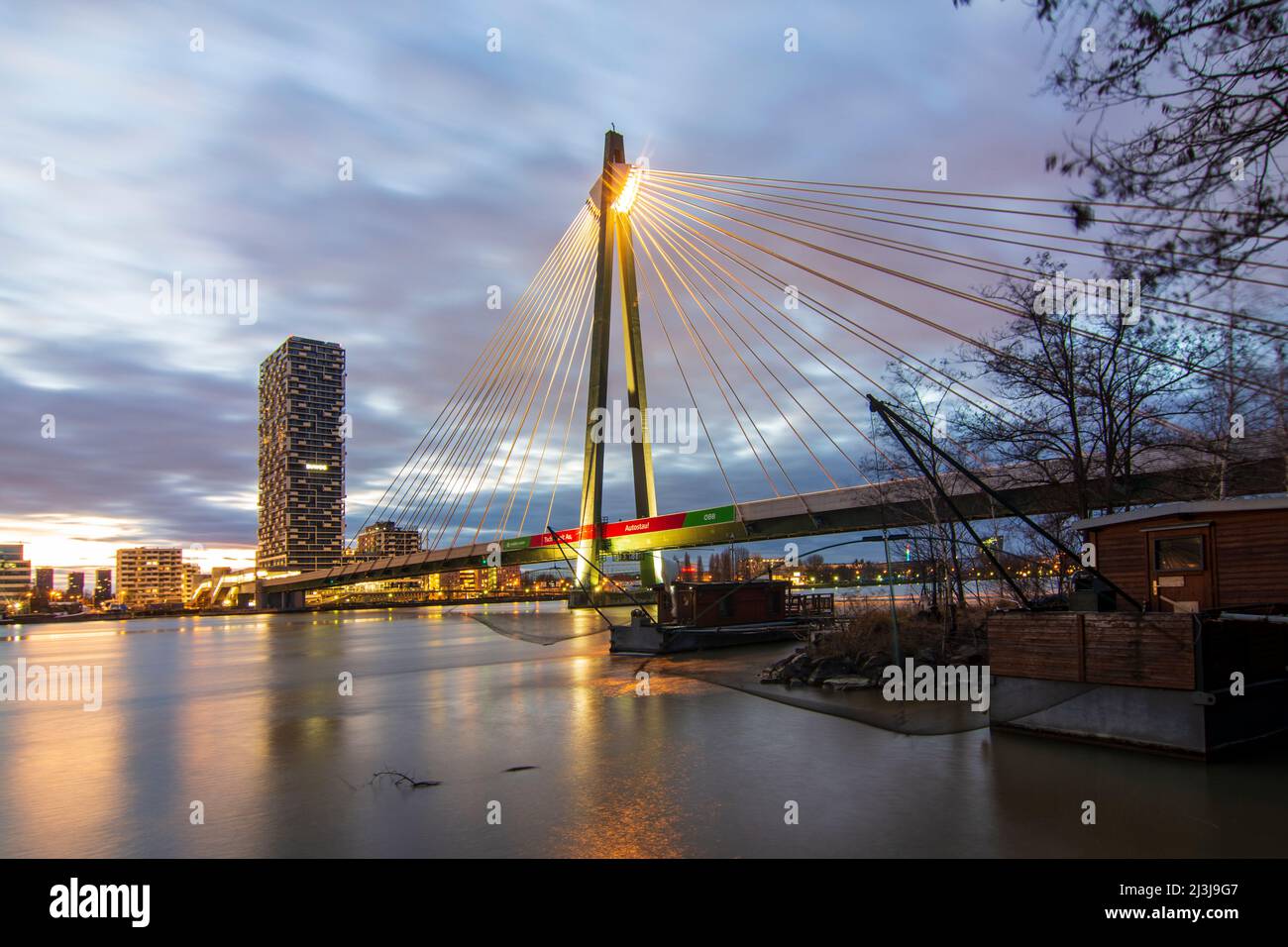 Vienna, fiume Donau (Danubio), ponte Donaustadtbrücke, Marinatower, barca con rete di sollevamento Daubel, linea U2 della metropolitana, nel 02. Leopoldstadt, Austria Foto Stock