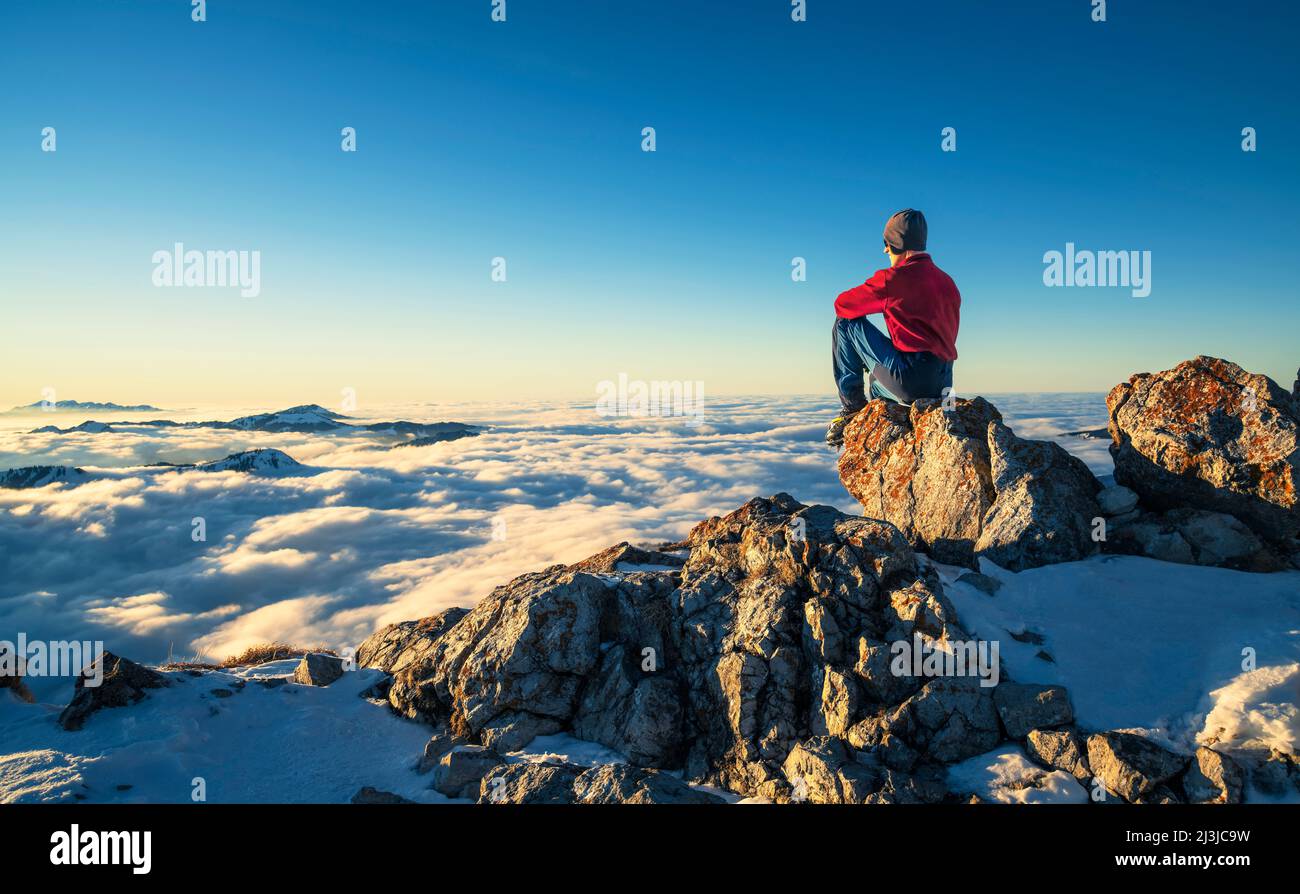 Alpinista godersi il tramonto sulla cima di Aggenstein in inverno. Allgäu Alpi, Baviera, Germania, Europa Foto Stock