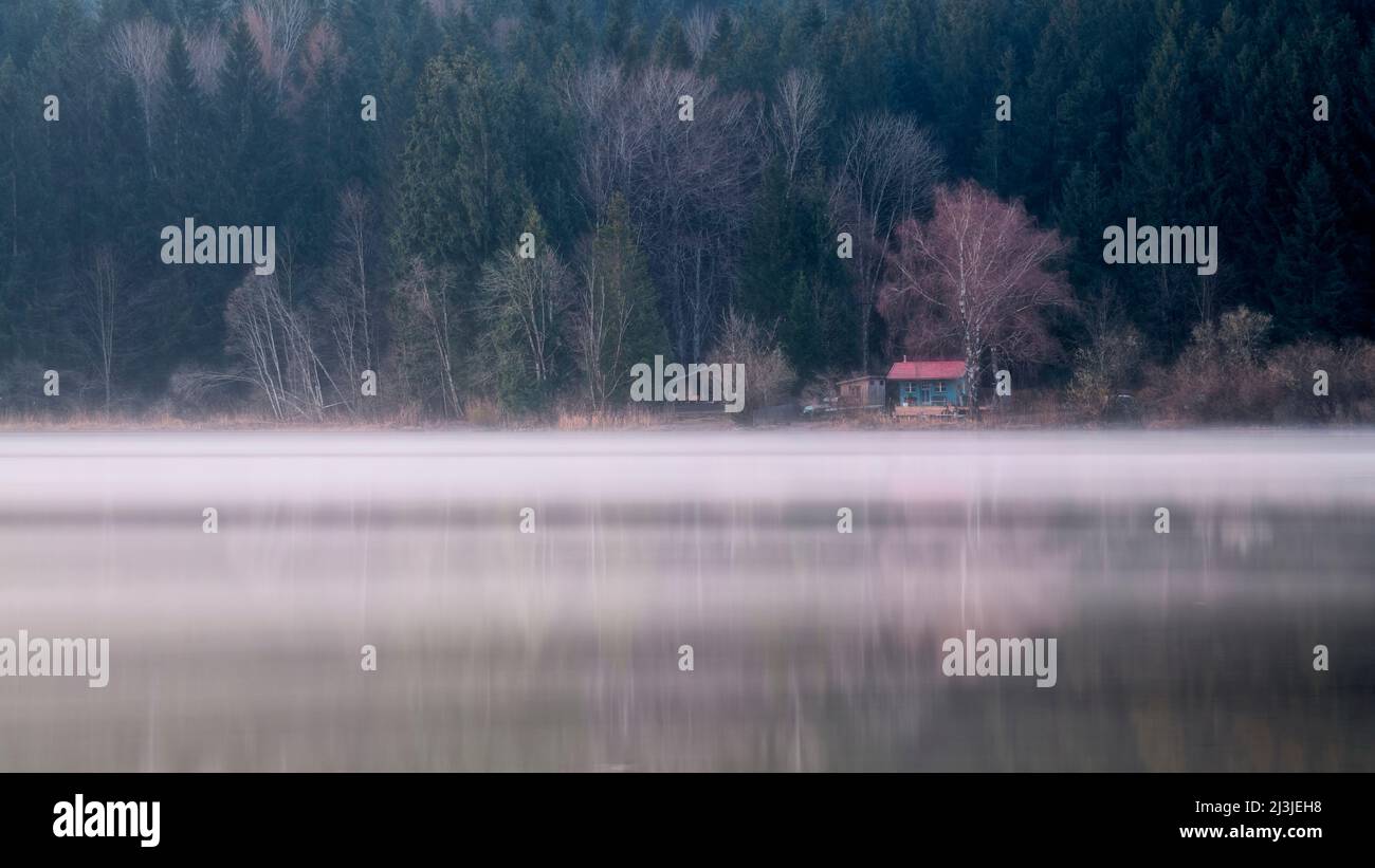 Piccola capanna all'alba di fronte alla foresta a Niedersonthofener See, Allgäu, Baviera, Germania Foto Stock