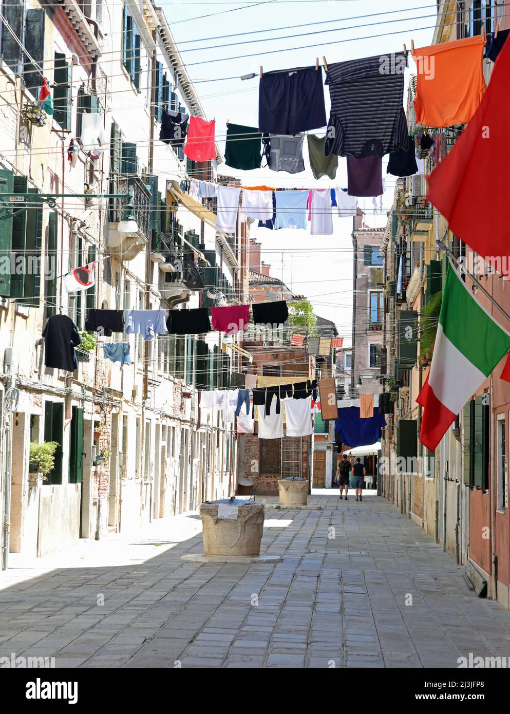 Le linee di lavaggio con i vestiti sopra la strada stretta chiamata CALLE nell'isola di Venezia nell'Italia settentrionale nella regione Veneto Foto Stock