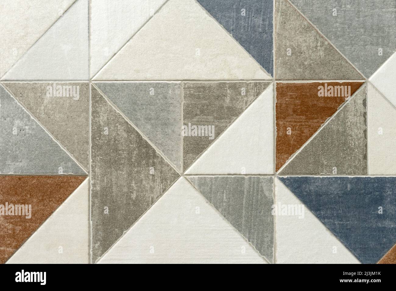 Piastrelle in ceramica realizzate in triangoli multicolore in ordine caotico. Foto Stock