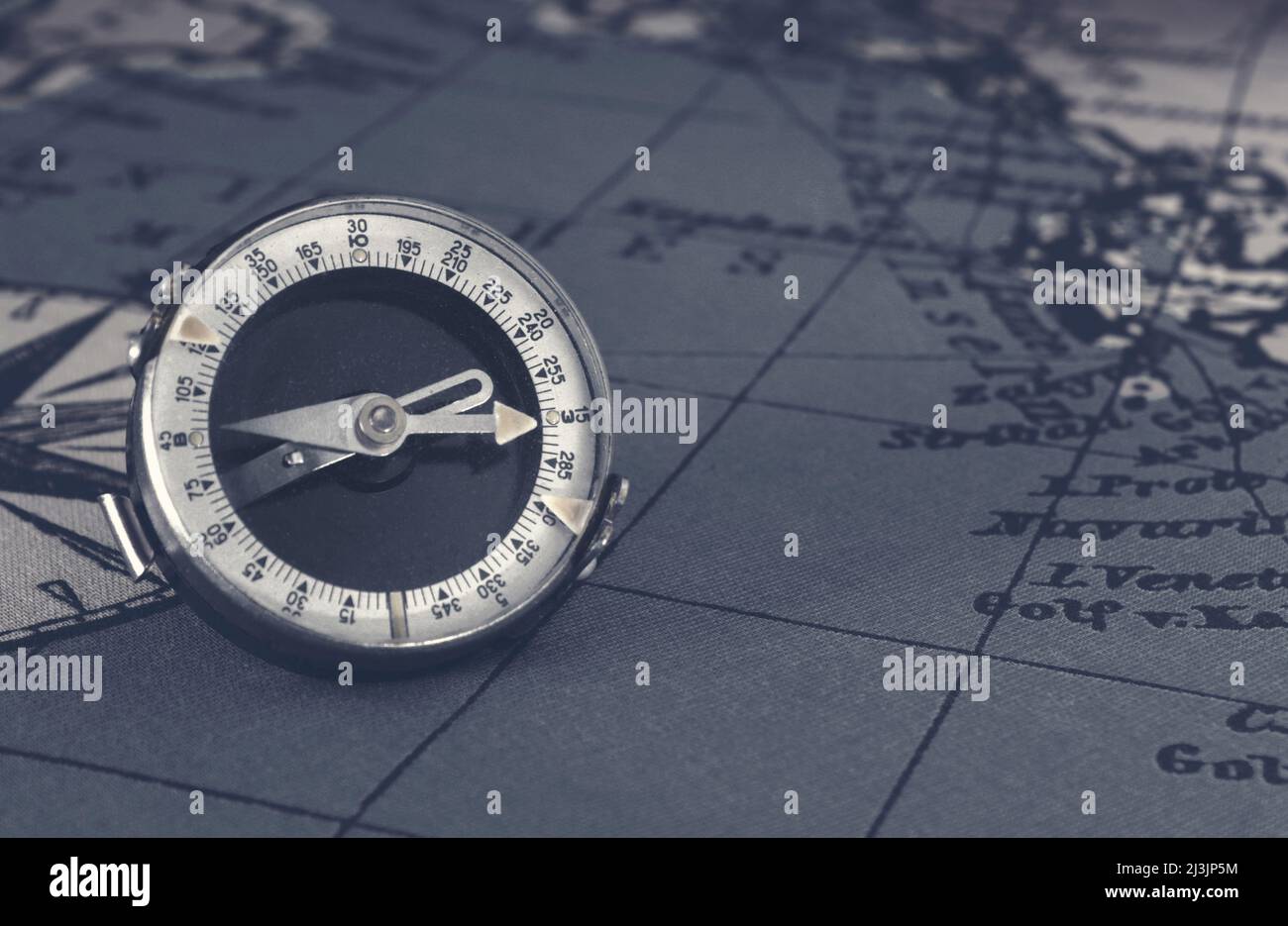 Vecchia bussola magnetica su mappa mondiale vintage.viaggio, geografia, navigazione, turismo e concetto di esplorazione background.Macro scatto, fuoco poco profondo. Foto Stock