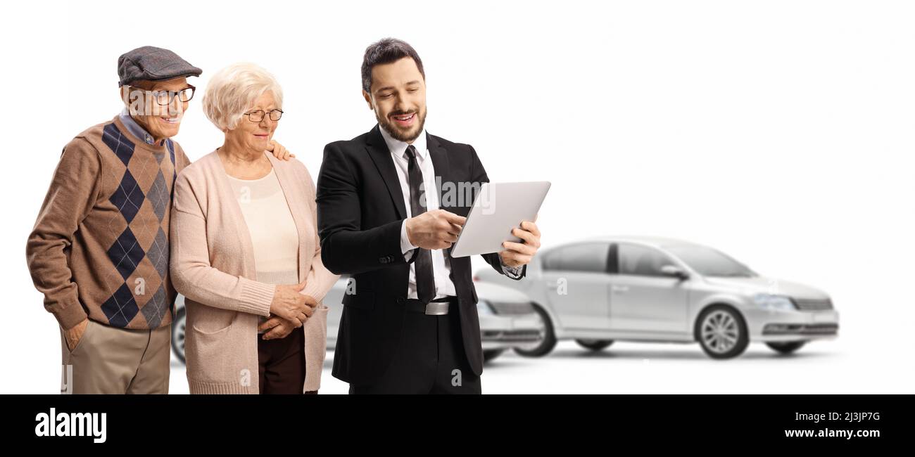 Uomo d'affari con un tablet che mostra a un uomo e una donna anziani in uno showroom auto isolato su sfondo bianco Foto Stock