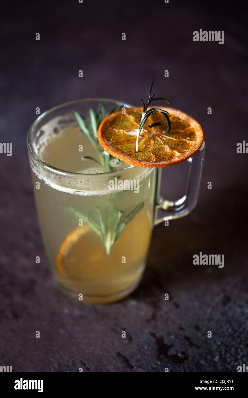 Primo piano tè caldo alle erbe con limone su sfondo scuro bar stand. Foto Stock