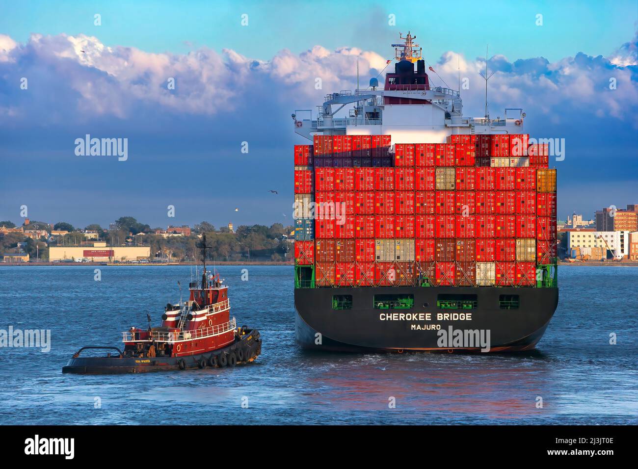 Cherokee Bridge container Ship and Tug, Port Elizabeth, NJ Loaded Container Ship Red Containers impilato 8 alto, il rimorchiatore che potrebbe, cielo blu e tardi Foto Stock