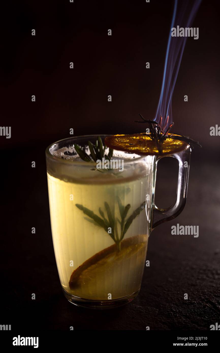 Primo piano tè caldo alle erbe con limone su sfondo scuro bar stand. Foto Stock