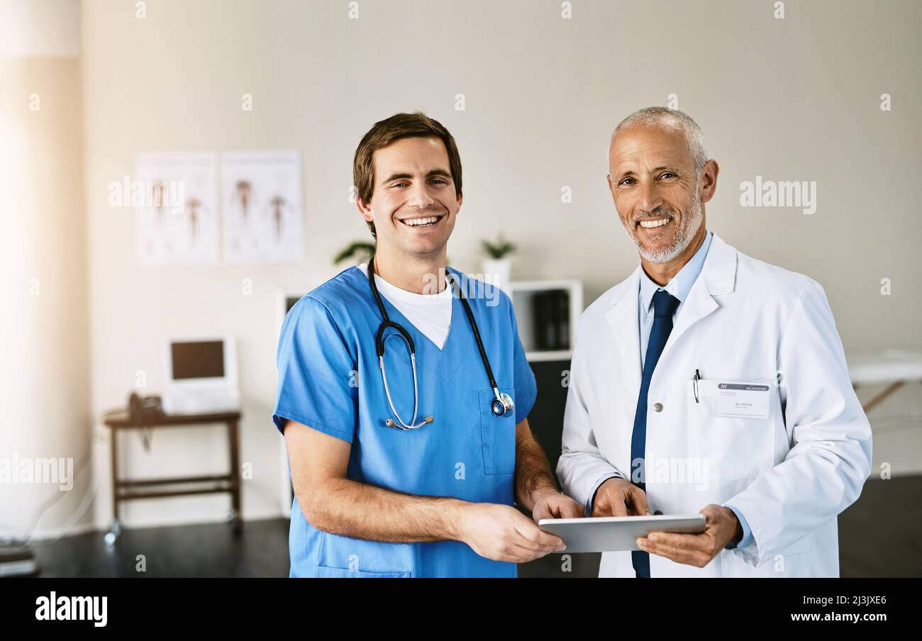 Utilizziamo tecnologie all'avanguardia nella nostra pratica. Ritratto di due medici che utilizzano un tablet digitale in un ospedale. Foto Stock