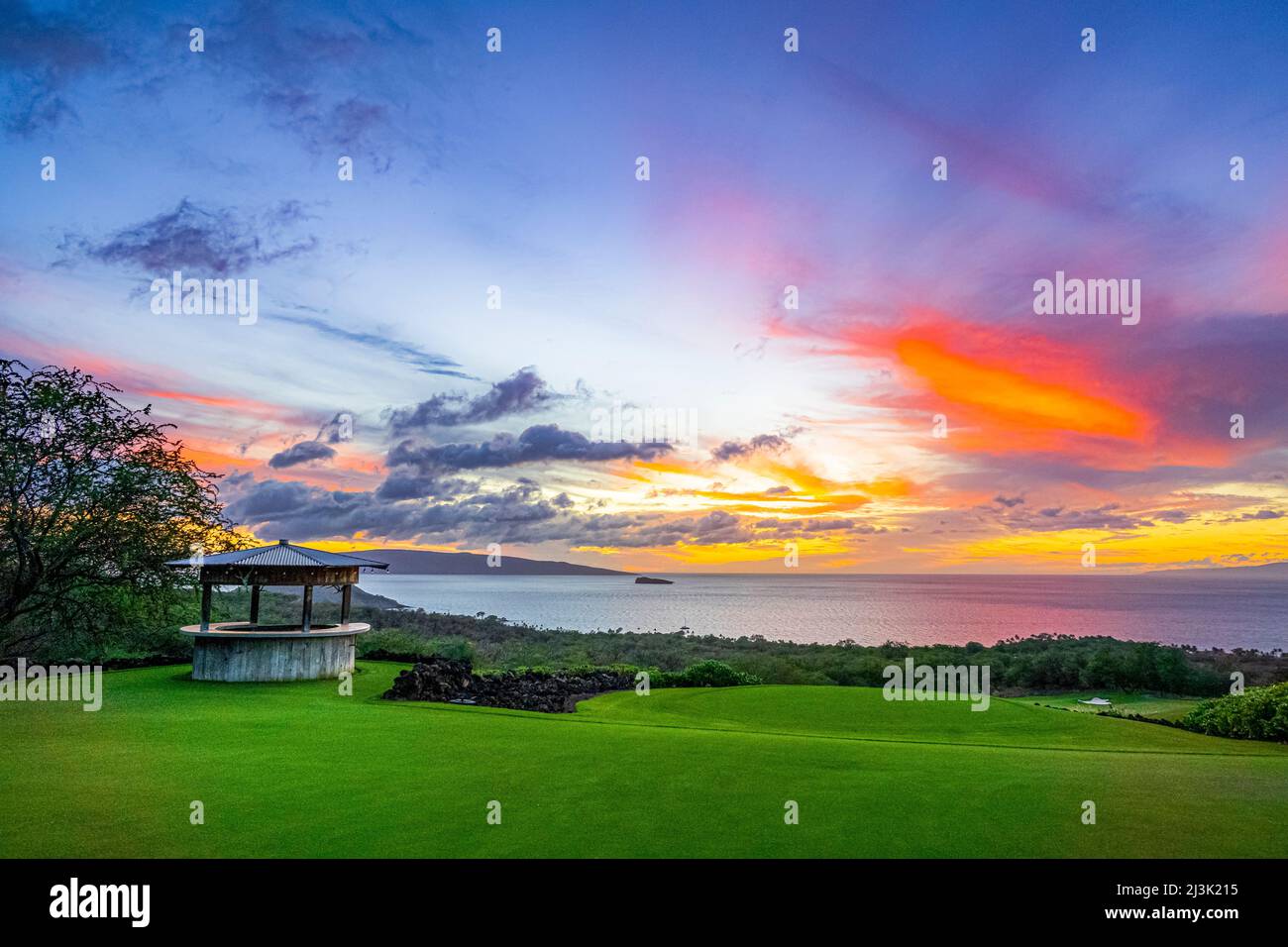 Colori vibranti in un brillante cielo tramonto, visto da una proprietà sulla costa di Maui, Hawaii, USA; Maui, Hawaii, Stati Uniti d'America Foto Stock