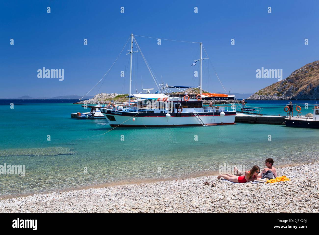 I bagnanti si godono la spiaggia di Sesklia sull'isola di Symi in Grecia; Symi, Dodecaneso, Grecia Foto Stock