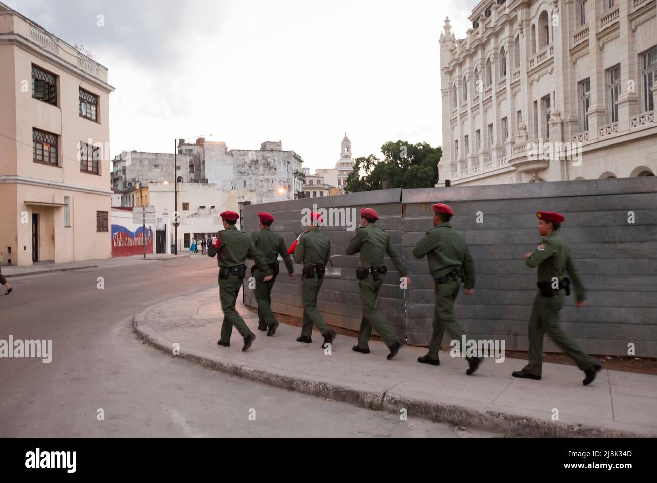 Diversi soldati camminano in formazione mentre trasportano una bandiera cubana attraverso le strade del centro di l'Avana, Cuba; l'Avana, Cuba Foto Stock