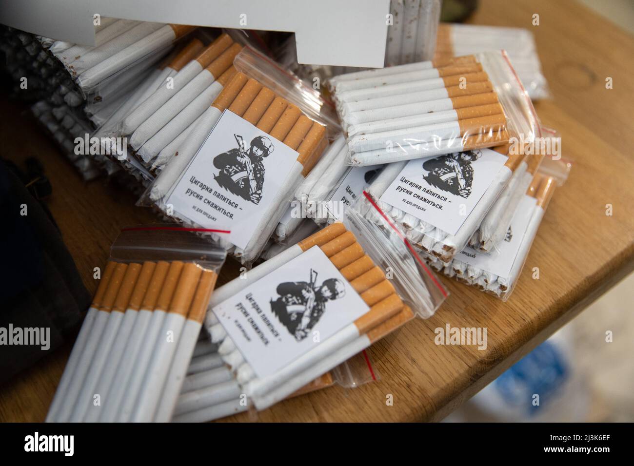 Le sigarette sono imballate da volontari, come saranno consegnate in prima linea per i soldati ucraini. Mentre la guerra progredisce, i cittadini di Kyiv si offrono volontariamente per aiutare la loro patria in modi diversi, come la distribuzione di cibo agli anziani, e la cucina per i soldati in prima linea. Foto Stock