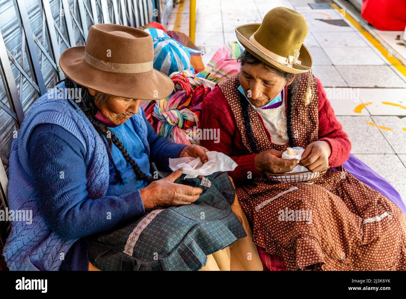 Due donne anziane seduti a mangiare uno spuntino al mercato di San Camilo, Arequipa, Regione di Arequipa, Perù. Foto Stock