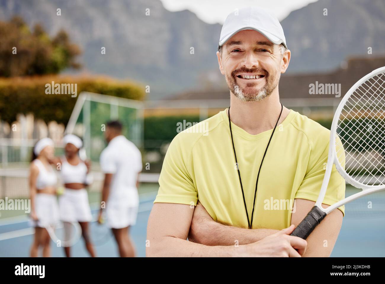 Do ai miei studenti solo il meglio. Ritratto corto di un bel allenatore di  tennis maschile maturo in piedi fuori con le braccia piegate e i suoi  studenti dentro Foto stock - Alamy