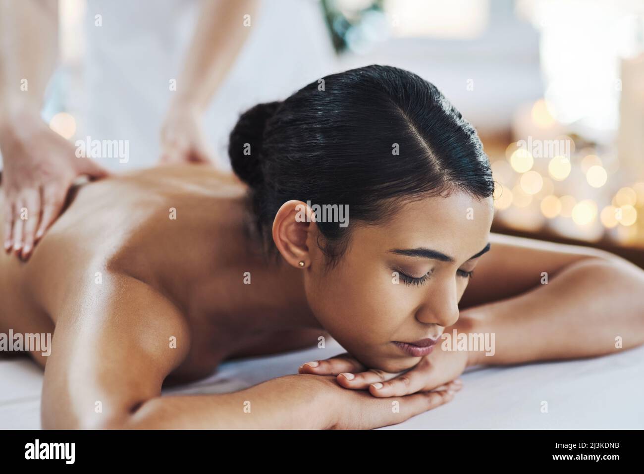 Mantieni la schiena dritta. Shot di una giovane donna allegra e rilassata che riceve un massaggio al coperto in una spa. Foto Stock