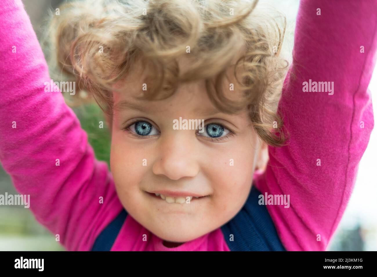 Ritratto di una giovane ragazza con capelli biondi ricci e grandi occhi blu; Toronto, Ontario, Canada Foto Stock