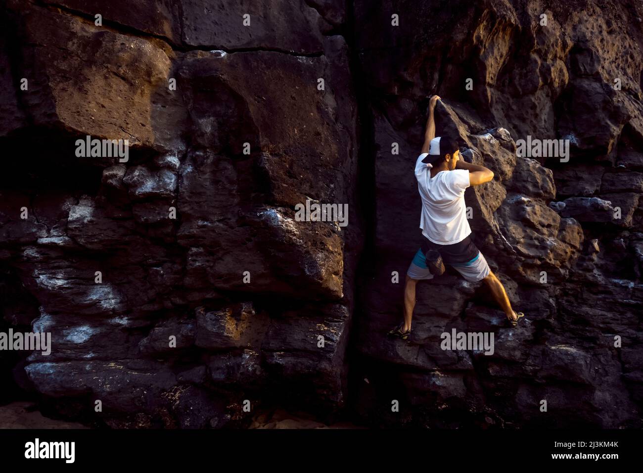 Un uomo bouldering sulla spiaggia in Oahu. Foto Stock