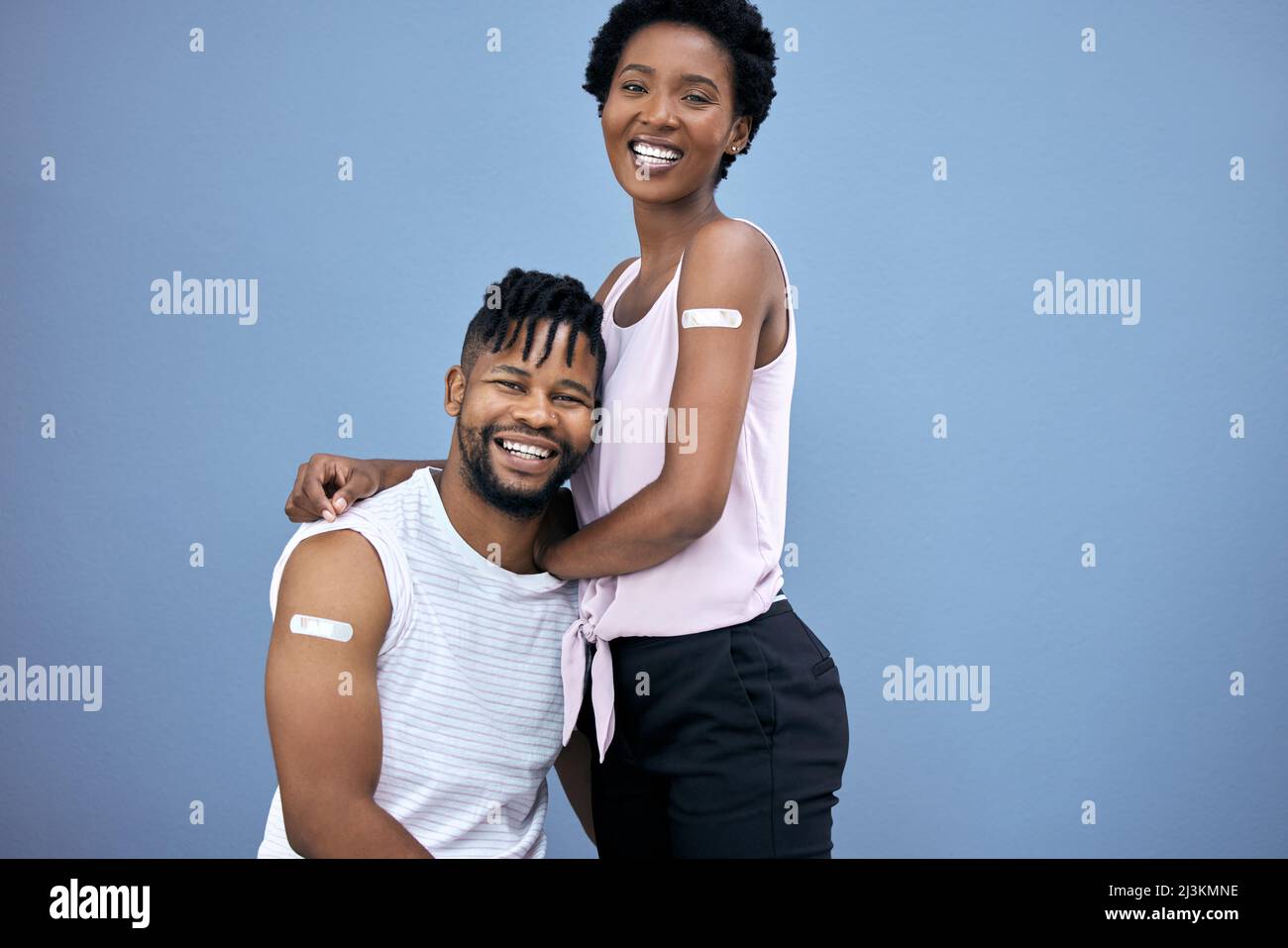 L'abbiamo fatto insieme. Shot di una giovane coppia che si posa insieme in studio dopo aver ottenuto i loro vaccini Covid. Foto Stock