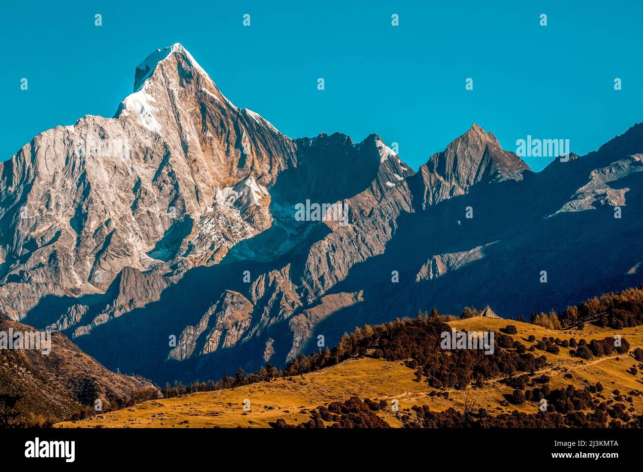 Terreno montuoso accidentato del Monte Siguniang sotto un cielo azzurro, Parco Nazionale di Siguniang; Prefettura di Ngawa, Sichuan, Cina Foto Stock