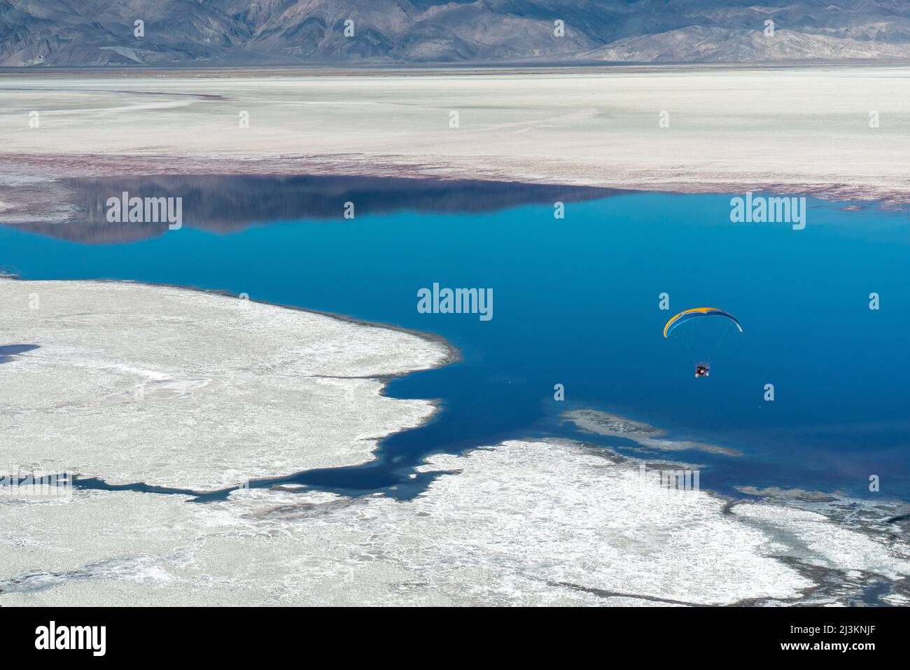 Un pilota paramotore vola sul lago Owens, un letto di lago per lo più asciutto, nella Sierra Nevada vicino a Lone Pine Foto Stock