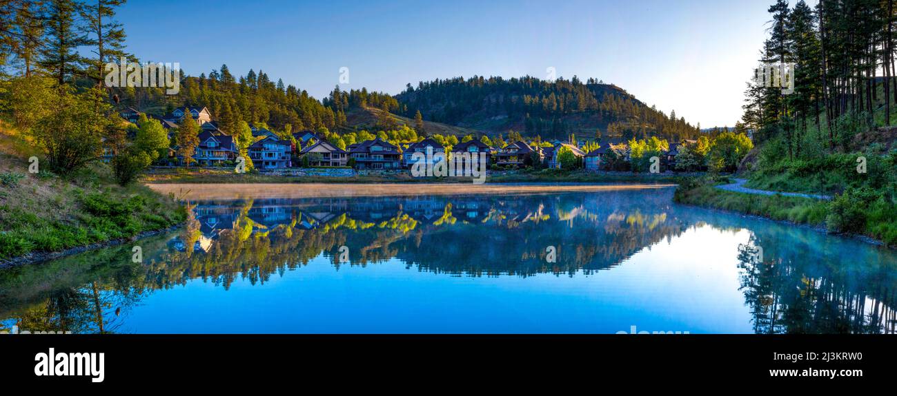 Alloggio in una comunità intorno a Still Pond all'alba a Kelowna, BC, Canada; Kelowna, British Columbia, Canada Foto Stock